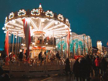 Group of people in amusement park at night