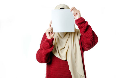 Midsection of person holding red umbrella against white background