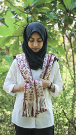 Young woman with scarf standing in forest