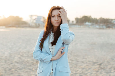 Portrait of beautiful young woman standing on land