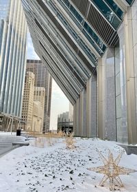 Modern buildings in city against sky during winter