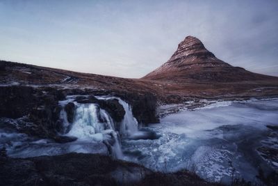 Scenic view of waterfall against sky