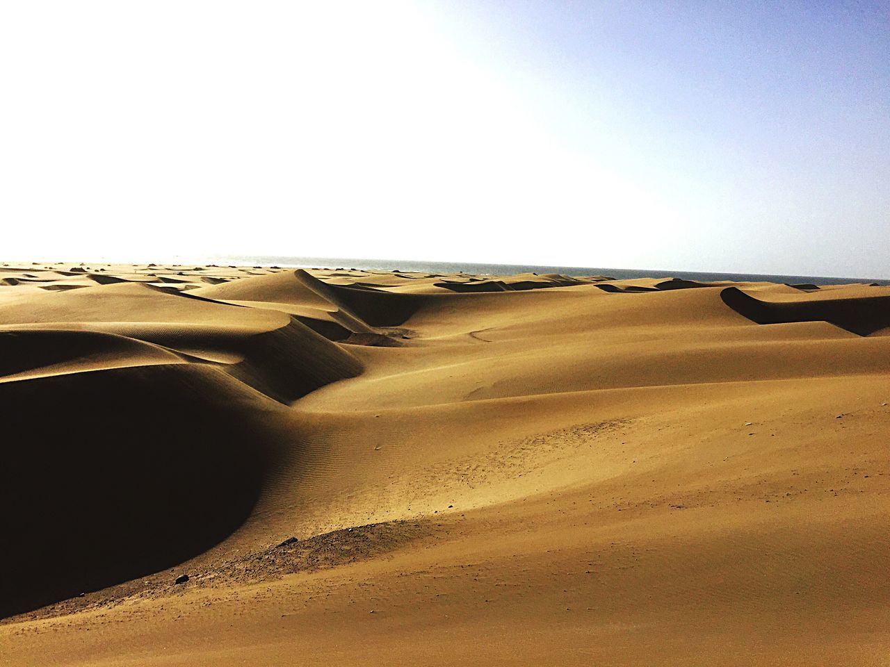 clear sky, desert, landscape, copy space, sand dune, sand, arid climate, tranquility, tranquil scene, scenics, horizon over land, barren, nature, transportation, beauty in nature, remote, sunlight, non-urban scene, extreme terrain, day