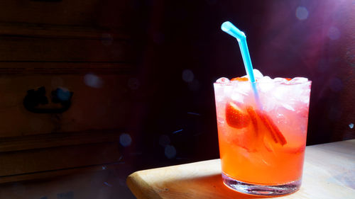 Close-up of cocktail served on table against drawer