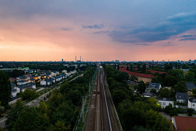 High angle view of street amidst buildings against sky during sunset