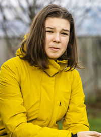Portrait of girl making sad face while sitting outdoors