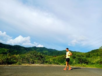 Rear view of man running on mountain against sky