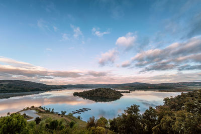 Scenic view of lake against sky at sunset