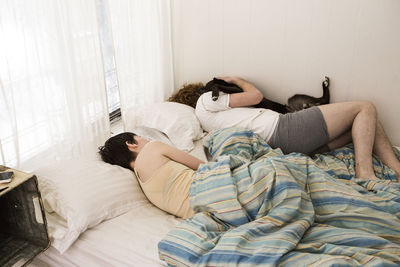 High angle view man and woman sleeping in bed at home