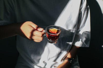 Midsection of man drinking glass