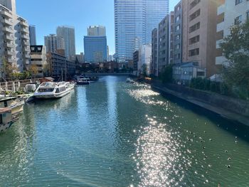 Canal amidst buildings in city against sky