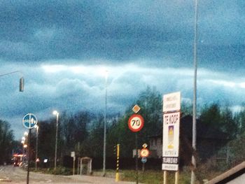 Road sign against cloudy sky