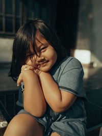 Portrait of a smiling girl sitting outdoors