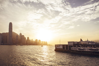 Scenic view of sea and buildings against sky during sunset