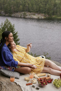 Female couple having picnic by river