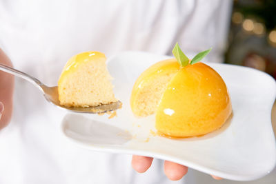 Close-up of hand holding ice cream in plate