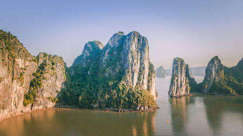 Panoramic view of rock formation in sea against clear sky