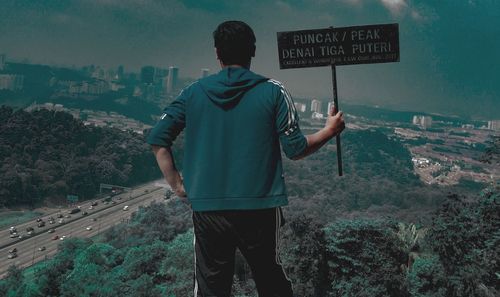 Rear view of man standing against city