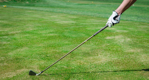 Cropped hand of man holding golf club