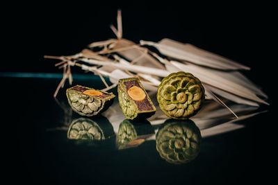 Close-up of fruits on table against black background