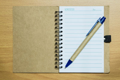 Directly above shot of pen and book on table