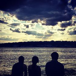 Silhouette of people in lake at sunset