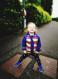Portrait of cute boy smiling on footpath