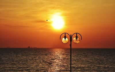 Scenic view of sea against orange sky