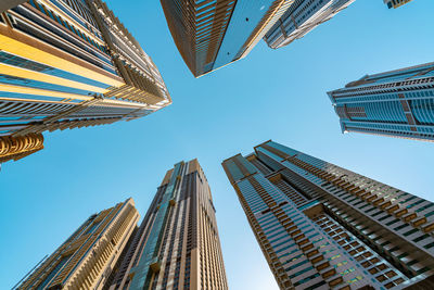 Directly below shot of modern buildings against clear sky