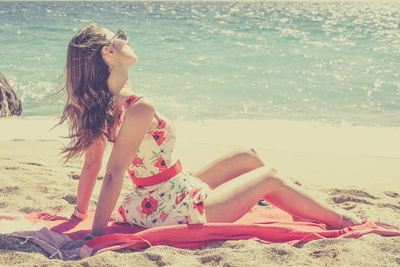 Young woman sitting at beach