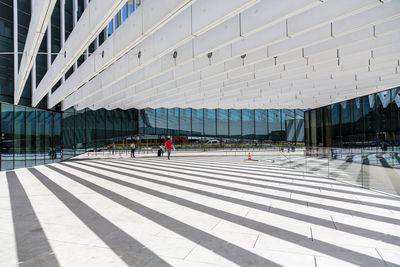 People walking on modern glass building in city