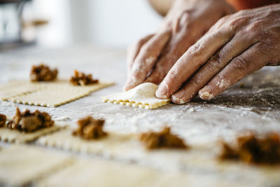 Cropped hands of male chef preparing food on table