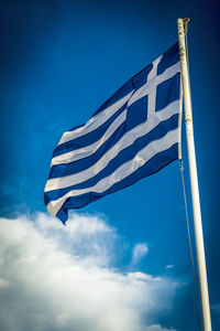 Low angle view of flag against blue sky