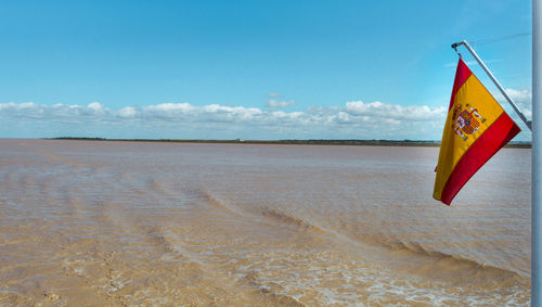Information sign on beach against sky