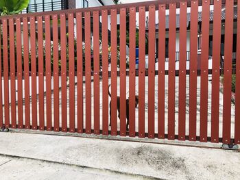 Footpath by fence against wall