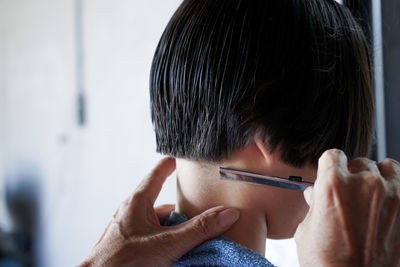 Closeup rear view head of man having a hair cut with battalion and comb