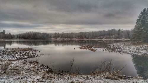 Scenic view of lake against cloudy sky during winter