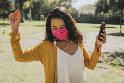 Young woman standing on mobile phone