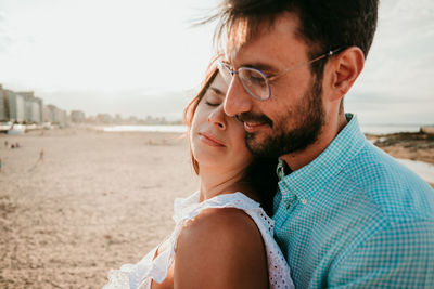 Portrait of young couple kissing on beach