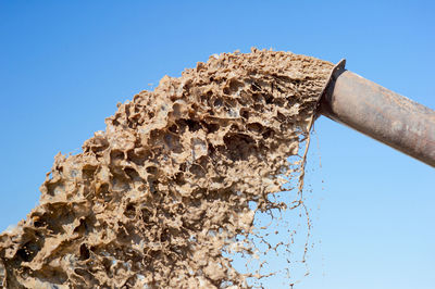 Low angle view of rusty metal against clear blue sky