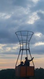 Low angle view of silhouette man standing against sky during sunset