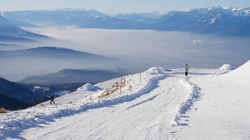 Panoramic view of people skiing on snowcapped mountains