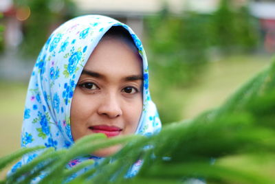 Close-up portrait of woman wearing hijab by plants in park