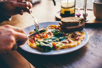 Cropped hands having omelet at home