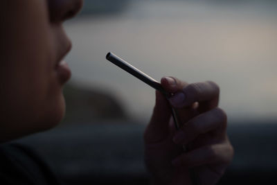 Close-up of hand holding cigarette