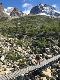 High angle view of woman walking on footbridge against mountain