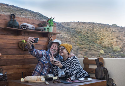 Smiling senior couple taking selfie on table