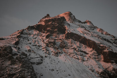 Low angle view of rock formation against sky during winter