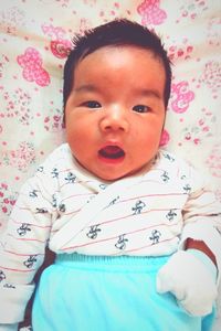 Portrait of cute baby girl on bed
