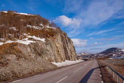 Road by mountain against sky